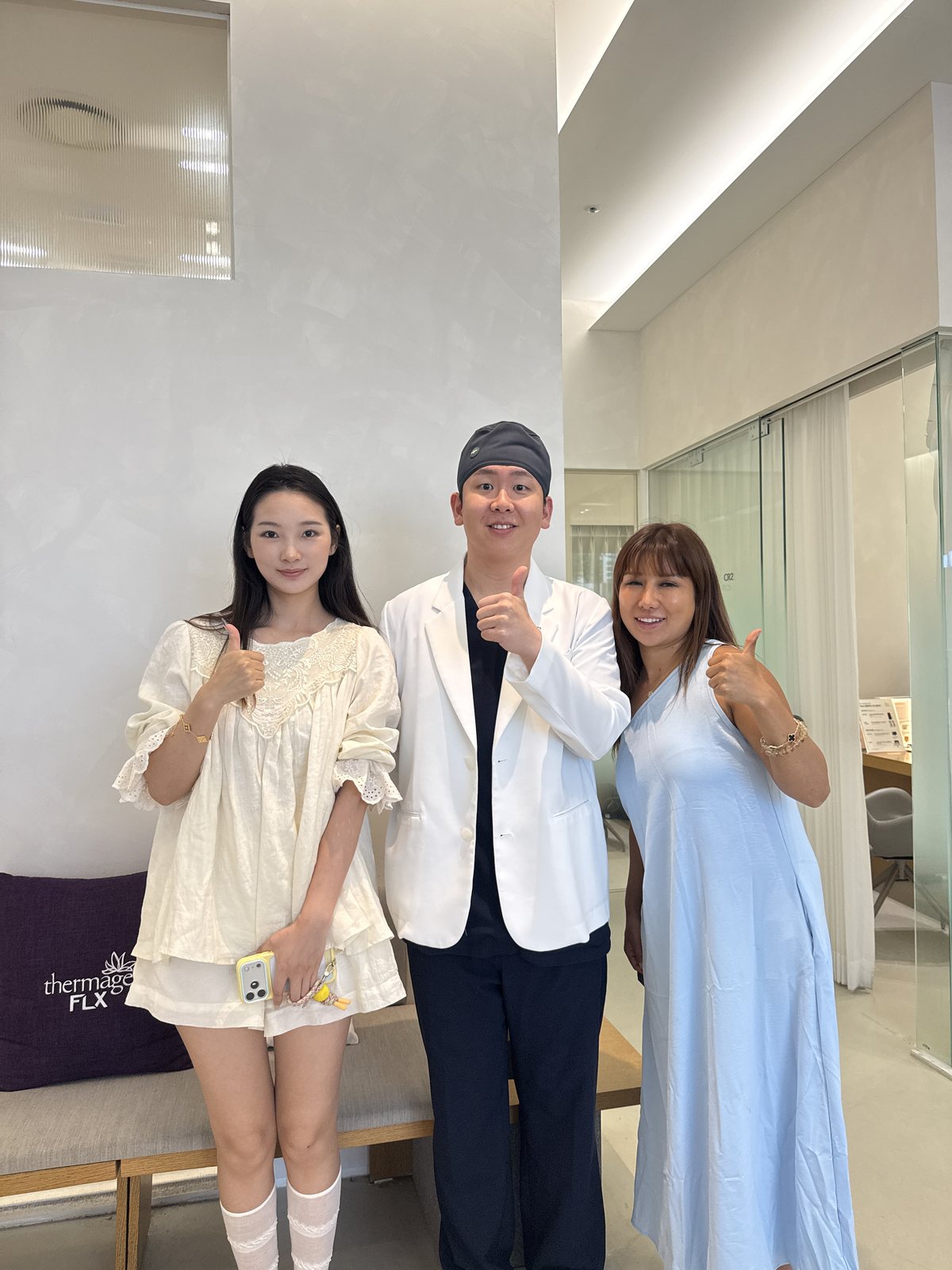 治疗结束后，李东润院长与两位受访者并排站立竖起大拇指的场景